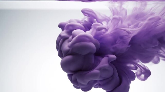 Purple ink swirling in water creating abstract patterns  