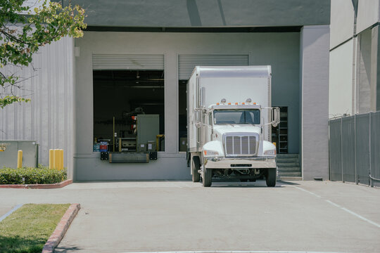 Delivery truck parked by a loading dock in a commercial area
