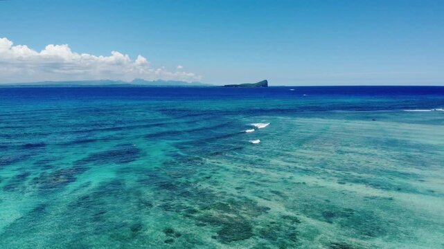 A stunning aerial view of Gunner&rsquo;s Quoin, also known as Coin de Mire Island, Mauritius. The image showcases dramatic volcanic cliffs surrounded by deep blue ocean waters, highlighting the island&rsquo;s bre