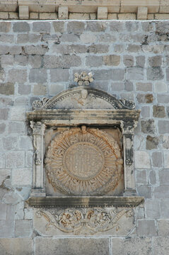 Close up view of the ancient medieval stone bas-relief with a circular IHS Christogram monogram placed above the historic Gate of Ponte in Dubrovnik Croatia.
