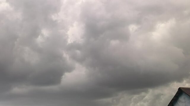 Heavy clouds fill the sky as a storm begins. Dark shades cover the atmosphere. The weather changes quickly, suggesting rain and lightning are on the way. People may seek shelter soon.