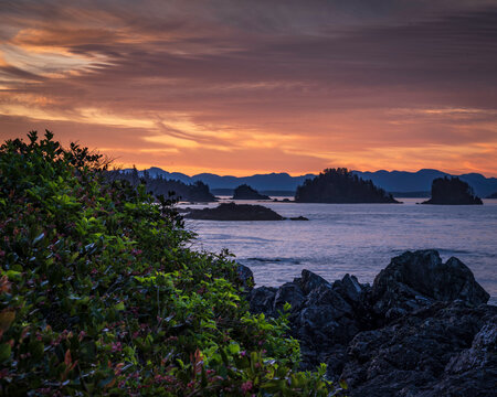 Vibrant sunrise over rocky ocean coastline and islands at dawn