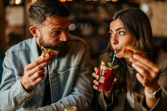 Couple enjoying cocktails and snacks during social dinner