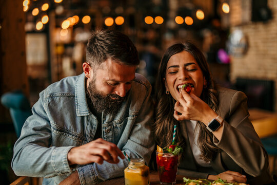Young couple enjoying drinks and food in a restaurant
