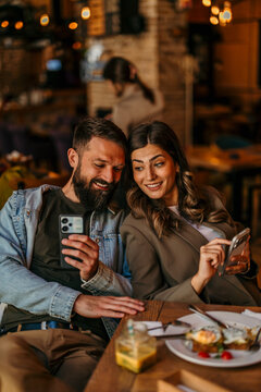 Couple enjoying brunch and connecting with smartphones
