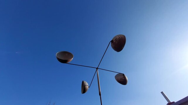 Vintage cup anemometer spinning fast in the wind against a clear blue sky background