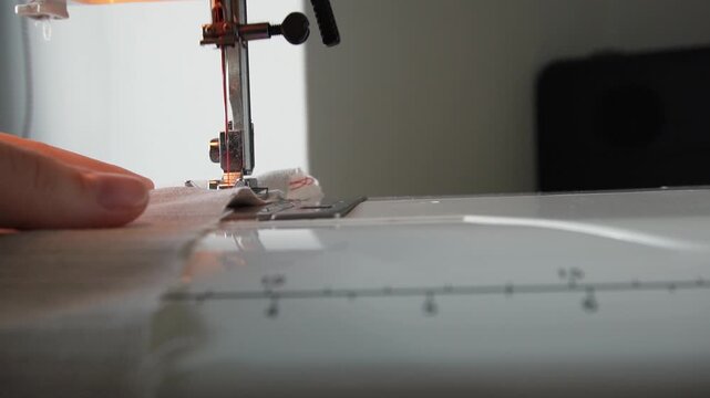 Macro shot of a sewing machine needle rapidly stitching fabric