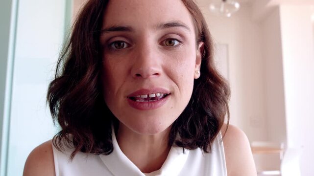 Face, woman and video call in home with wave hello, connection and online communication on weekend. Happy, person relax and greeting in living room with virtual contact POV, conversation and network.