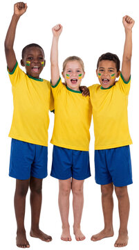 Young Football Fans Celebrate Victory: Three diverse young children, with painted faces and matching yellow jerseys, cheer ecstatically with their arms raised in triumph.