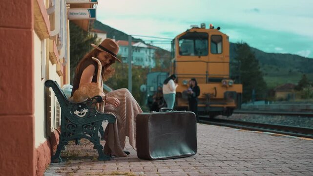 Serene woman with a cat waits at station