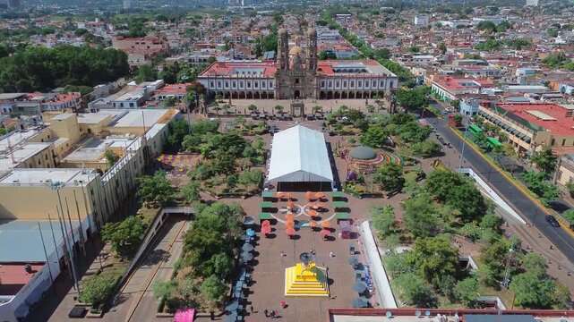 Basilica of Our Lady of Zapopan Featuring a Cinematic Aerial Drone Push In Flight Over the Entrance Avenue and Public Square under a Clear Blue Sky in Jalisco Mexico