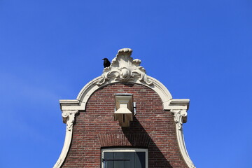 Obraz premium Bell Gable Close Up with Black Crow Against a Blue Sky in Amsterdam, Netherlands