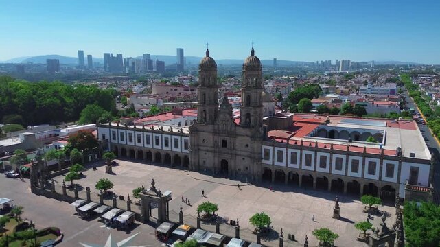Basilica of Our Lady of Zapopan Featuring a Cinematic Aerial Drone Push In Flight Over the Entrance Avenue and Public Square under a Clear Blue Sky in Jalisco Mexico