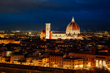 Fototapeta premium Wide angle night panorama of illuminated Florence historic center with glowing streets and Renaissance architecture lit up in warm golden light