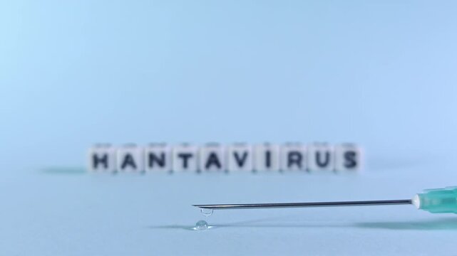 Macro rack focus from Hantavirus text blocks to a medical syringe needle with a forming liquid droplet. Illustrates pharmaceutical research, vaccine trials, and antidote development.