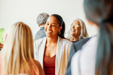 Smiling Black businesswoman networking with diverse professionals