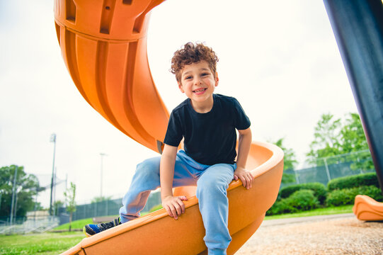 Happy kid slide on playground on summer season