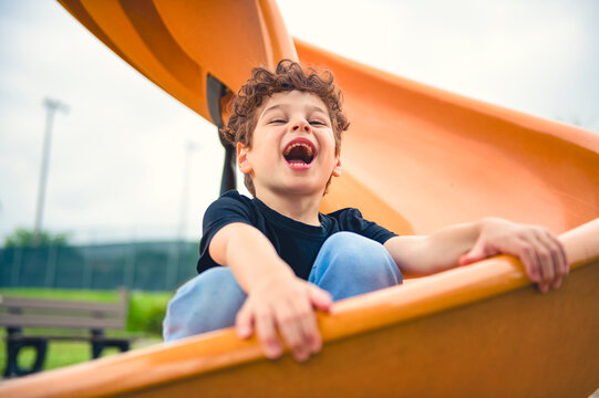 Happy kid slide on playground on summer season