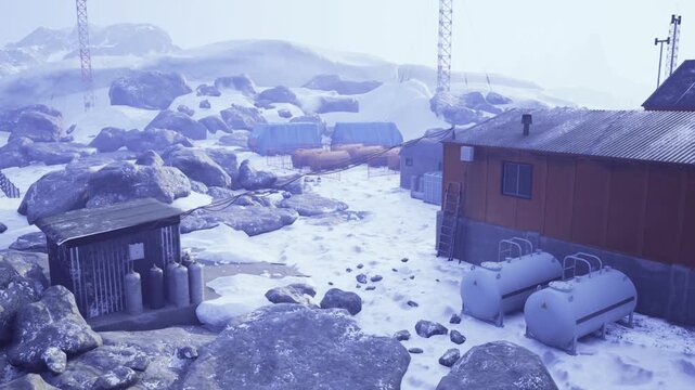 Distant research camp among snowy rocks and corrugated modules, clusters of drums and containers near insulated housing, pale blue light with long shadows,