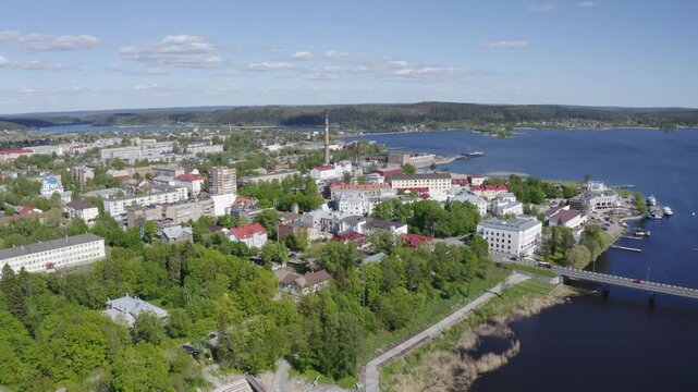 Backward reveal aerial shot of Sortavala town and Ladoga lake on sunny summer day. Karelia, Russia.