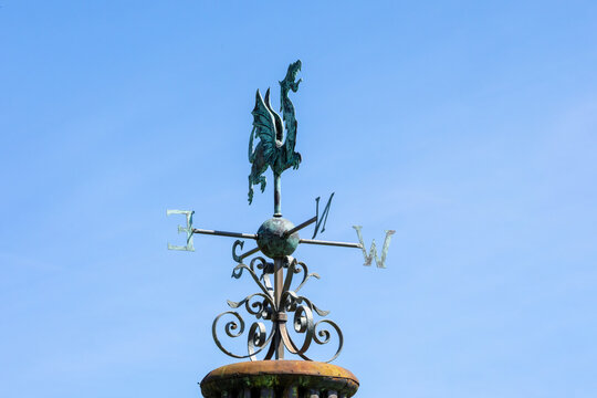 Dragon weather vane, wind vane, weathercock pointing toward the North. Wind direction instrument, with letters for compass points. 