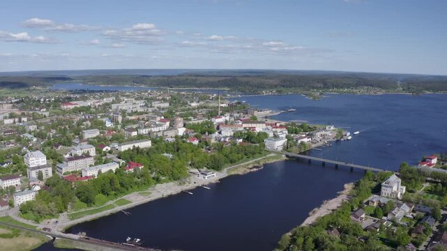Forward reveal aerial shot of Sortavala town and Ladoga lake on sunny summer day. Karelia, Russia.
