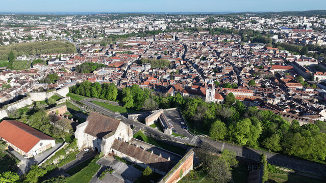Aerial view of Besancon Citadel overlooking the historic city center with its red-tiled rooftops and lush green trees under a clear blue sky in Besancon, Bourgogne-Franche-Comte, France.