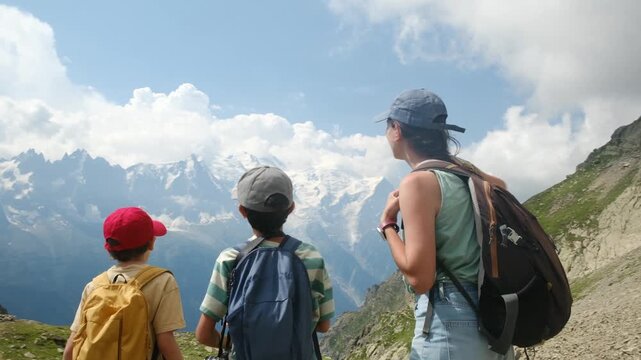 Mother and two sons enjoying a trekking adventure and pointing at the majestic mont blanc mountain range, symbolizing family bonding and active lifestyle in the french alps