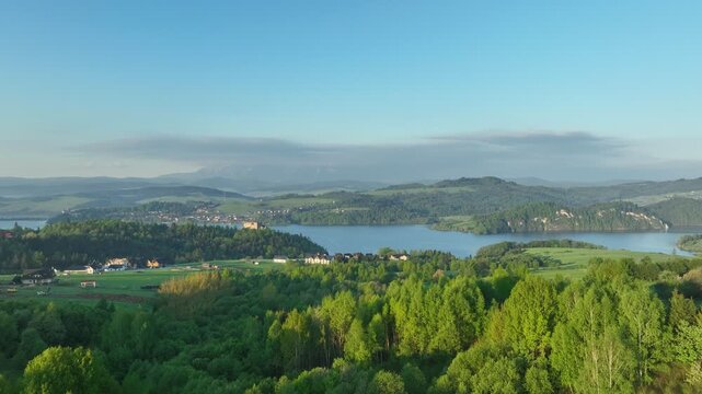 Scenic drone shot of Czorsztyn lake surrounded by green hills at sunny morning, spring landscape in Pieniny region