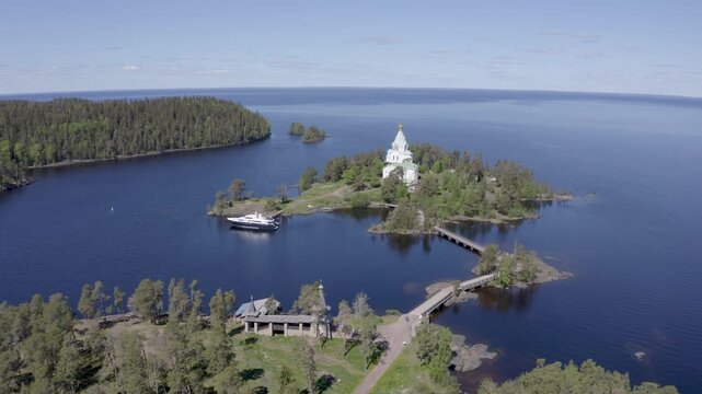 Forward reveal aerial shot of St. Nicholas Skete of Valaam Monastery on sunny summer day. Ladoga lake, Karelia, Russia.
