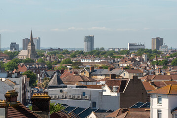 Obraz premium Southsea Portsmouth England UK.21.05.2026. A sprawling cityscape unfolds under a bright blue sky, showcasing a mix of residential buildings and the distant shimmering ocean horizon