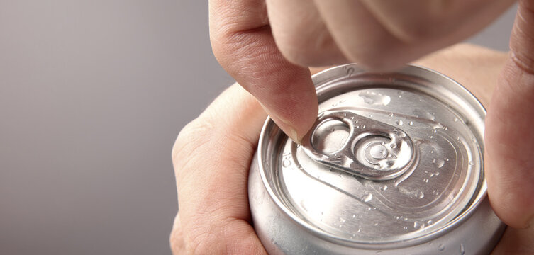 Cola or soda can opening. Close up of hand open aluminum beverage can with pull tab. Refreshing Cola or soda carbonated soft drink container with metal texture condensation droplets and easy open lid