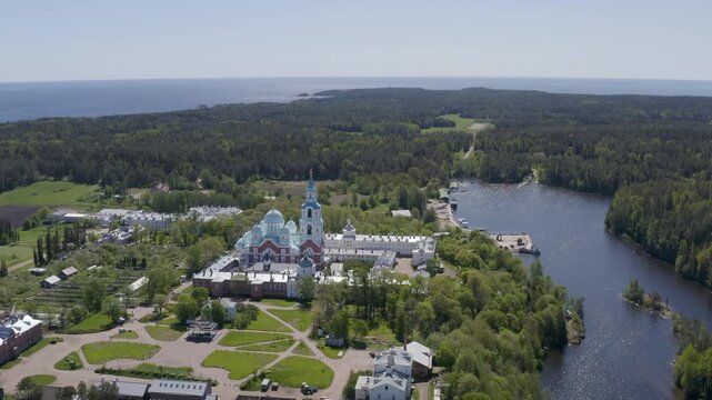 Backward aerial shot of Valaam Monastery and Monastery bay on sunny summer day. Ladoga lake, Karelia, Russia.