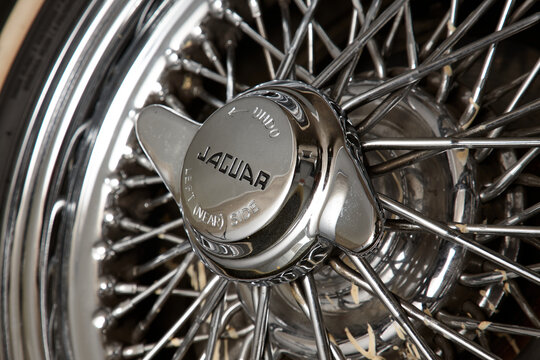 A vintage Jaguar E-Type wire wheel shows the metal hub and spokes in detail. The craftsmanship and design are clear. This is a classic car feature. Warsaw, Poland, 28.09.2008