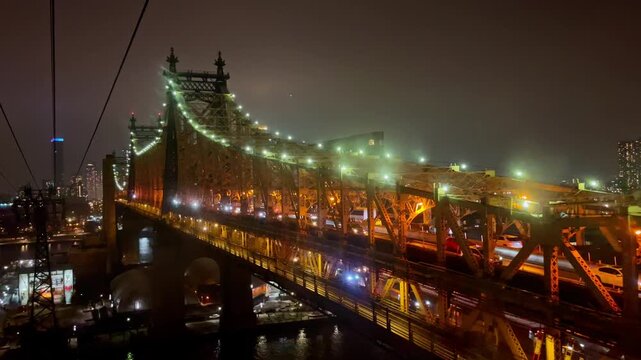 Car headlights riding by the bridge sparkle beautifully at night. Footage at the gorgeous Queensboro Bridge in New York City with luminous illumination.