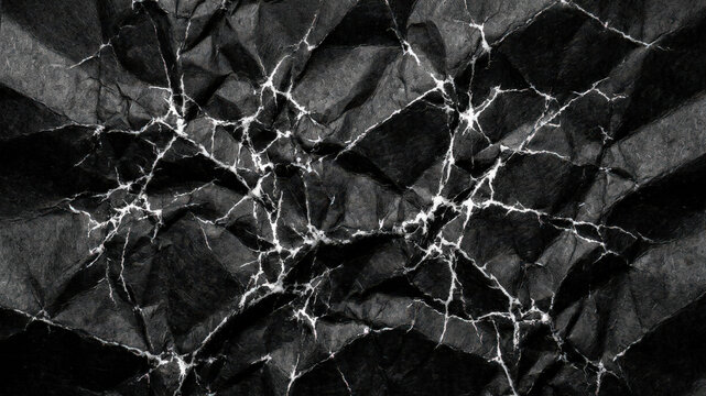 Crumpled black paper texture with sharp white highlighted creases