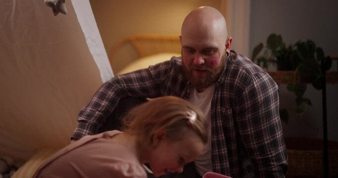 Daughter Putting Makeup on Her Bald Bearded Father While Playing in a Cozy Blanket Fort