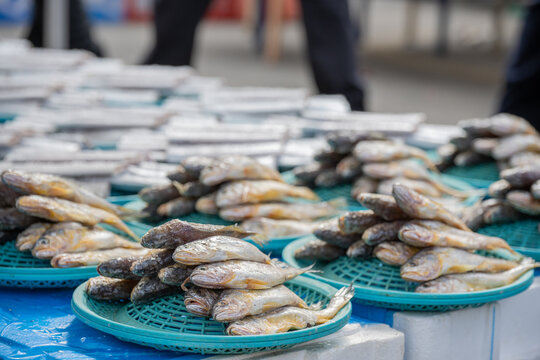 Fresh yellow croaker fishes displayed on plastic baskets at a street market
