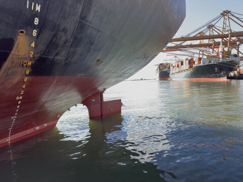aft part of the ship with draft marks and rudder, helm. vessels moored in port to container terminal