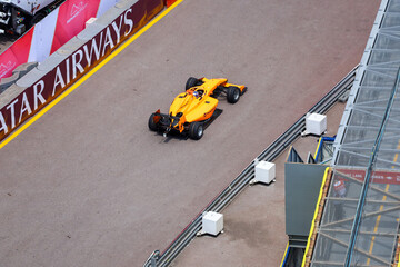 Fototapeta premium Monte Carlo, Monaco on May 23, 2024. High-Angle Shot of Harris Group Orange Formula Racing Car on the Monaco Circuit.