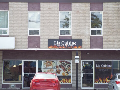 Gatineau, Quebec, Canada &ndash; April 21, 2026: A restaurant storefront for "Lia Cuisine" features fire-themed signage and window graphics, located at 693 Boulevard Saint-Joseph.