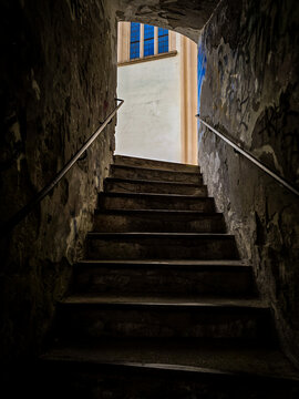 View of a church wall and window from a dark historic passageway in Boskovice