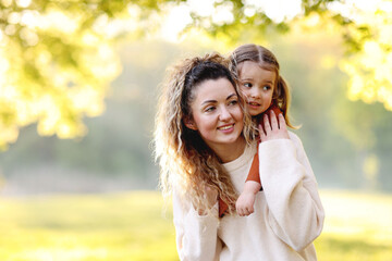 Fototapeta premium Mother with her cute little daughter in nature on sunny day. Space for text