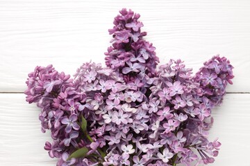 Obraz premium Branches with tender lilac flowers on white wooden table, top view