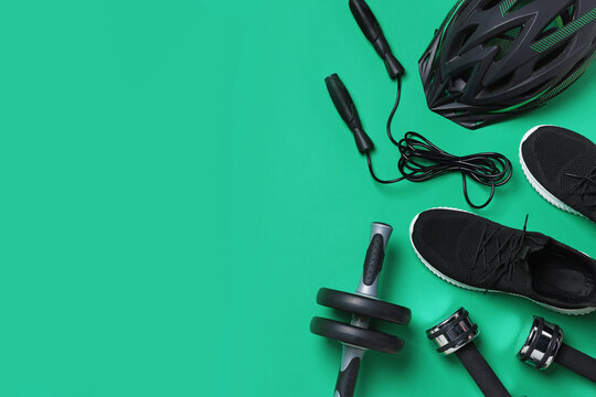 Different sports equipment and sneakers on green background, flat lay. Space for text