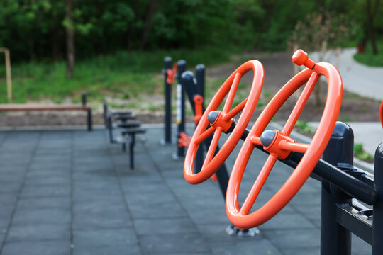 Empty outdoor gym with exercise equipment in park, closeup. Space for text