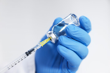 Fototapeta na wymiar Vaccination. Medical worker filling syringe with medication indoors, closeup