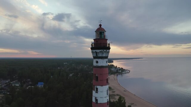 Orbital aerial shot of upper part of Osinovetsky lighthouse and Ladoga lake on summer sunset. Ladozhskoye Osero village, Leningrad Oblast, Russia.
