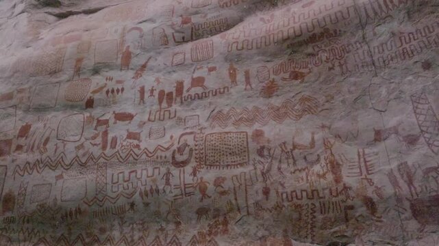 Vibrant Red Pictographs on Rock Face in Guaviare. Intricate patterns and figures depict historical scenes.