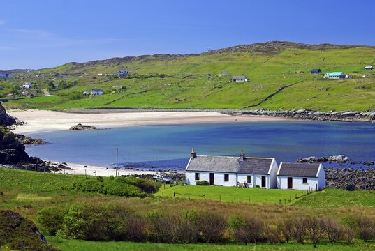 Small cottage in front of long sandy beach in green landscape, Highlands, Lochinver, Scourie, Western Scotland, Scotland, United Kingdom